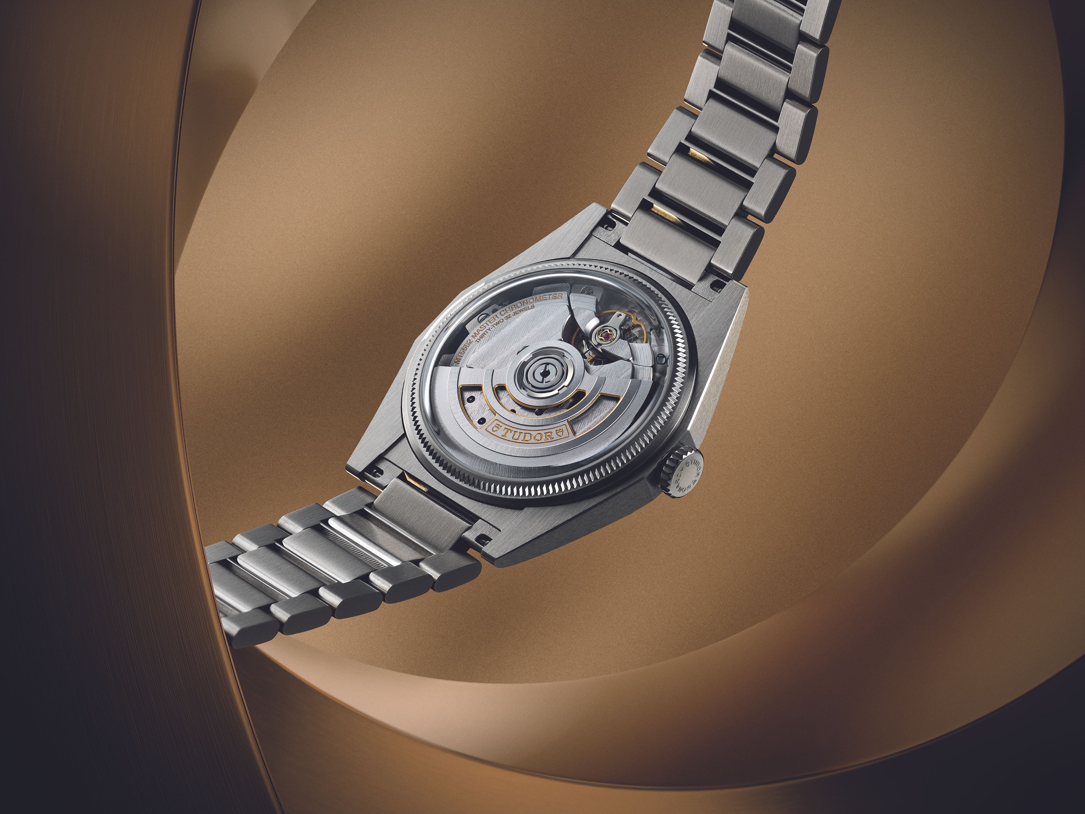 Close up of Tudor automatic movement visible through caseback with integrated bracelet highlighting mechanical craftsmanship