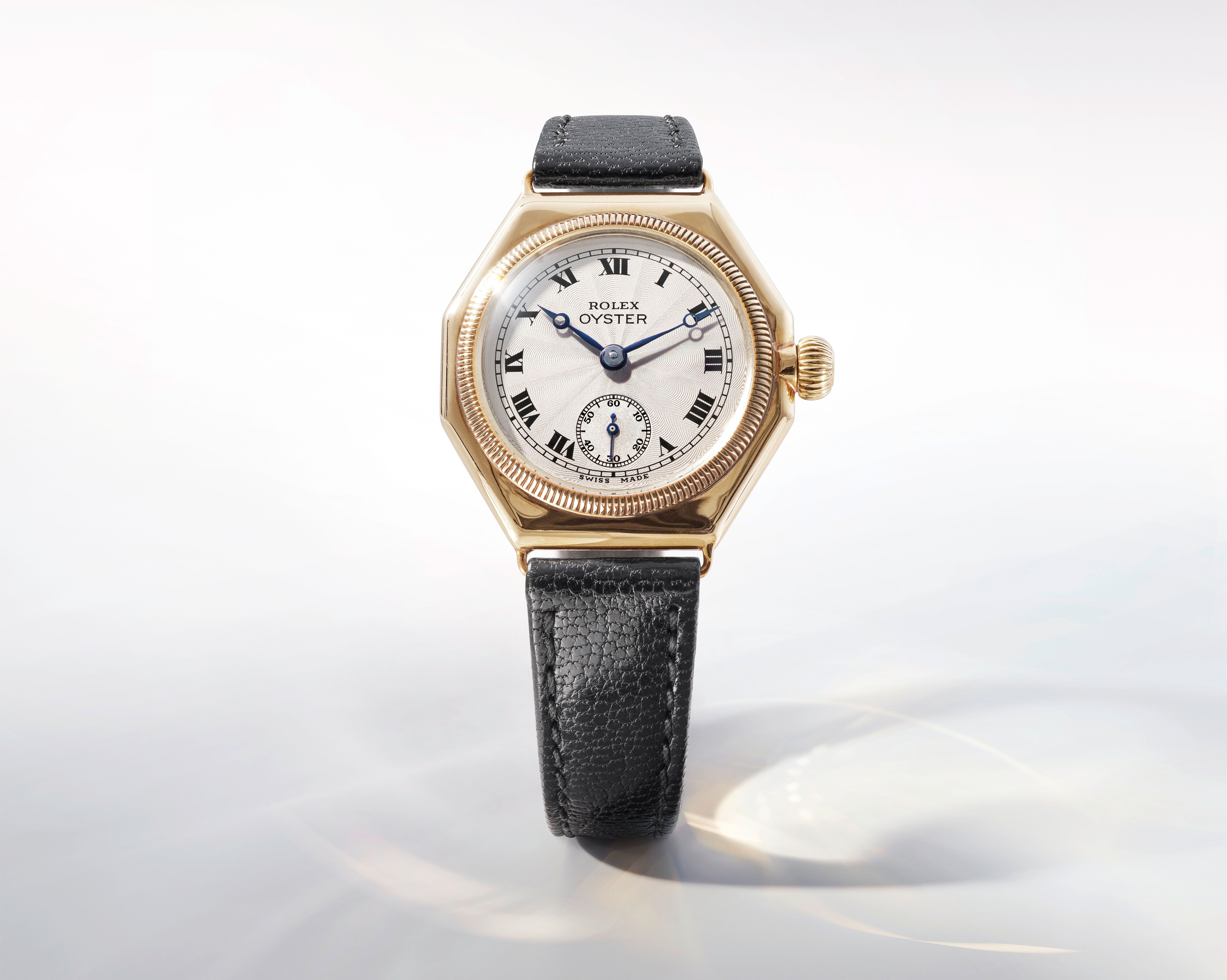 The first Rolex Oyster Perpetual from 1926 featuring an octagonal gold case and black leather strap